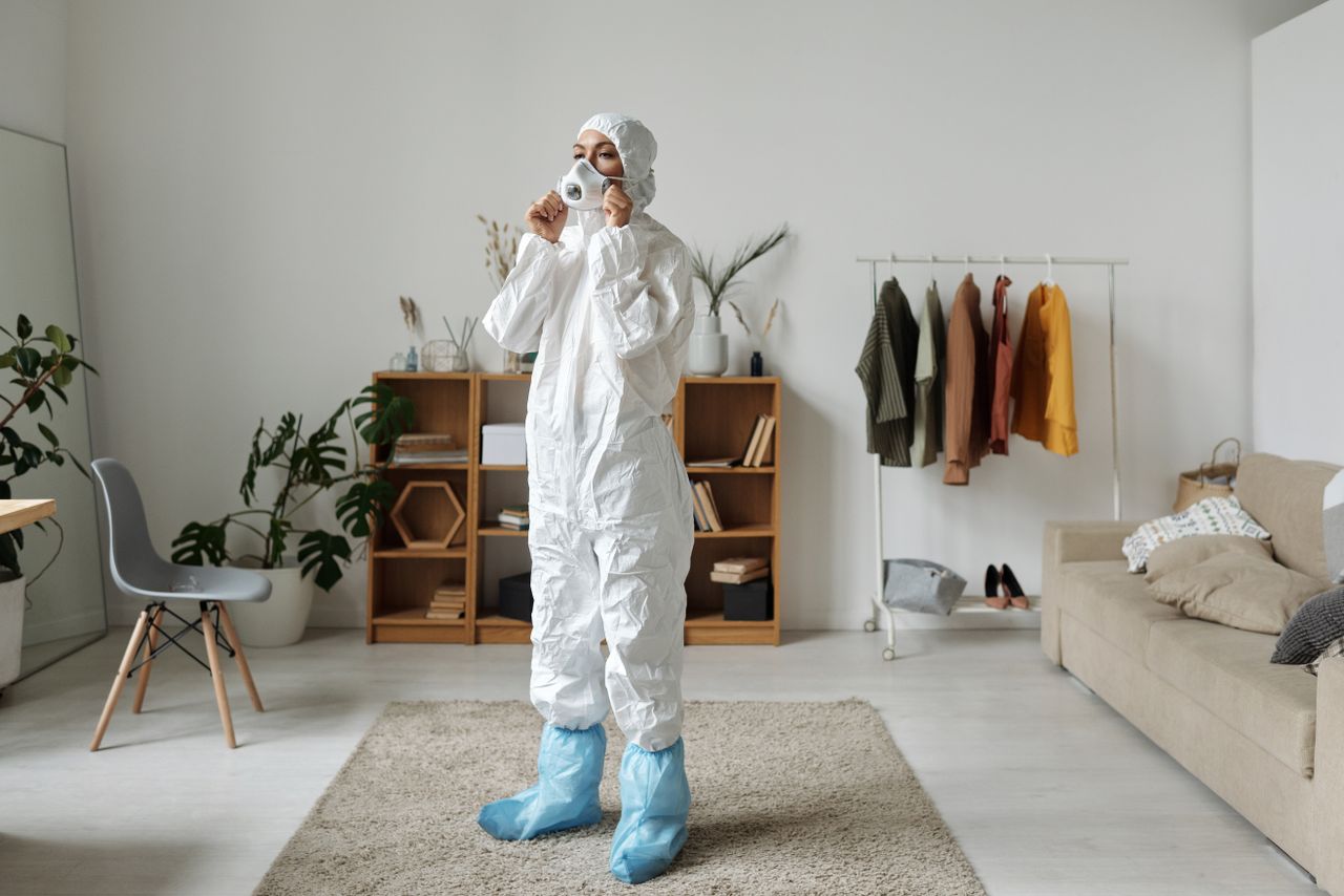 services-02 Woman in protective suit wearing face mask indoors with modern interior design.